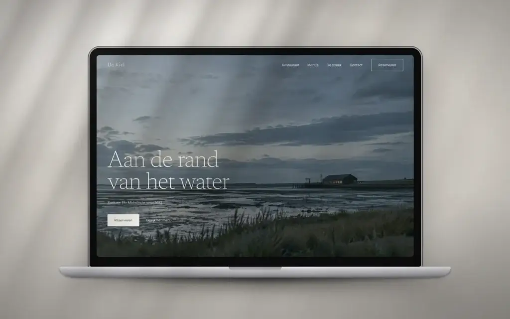 Homepage van restaurant De Kiel op een laptop: schorren bij schemer met de kop Aan de rand van het water