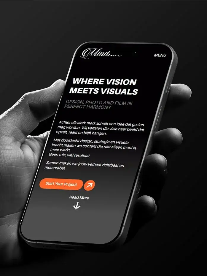 De Mindtive-site op een telefoon in een hand, zwart-wit met een oranje knop