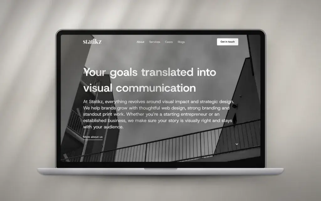Homepage van Statikz op een laptop: zwart-witfoto van een trappenhuis met de kop Your goals translated into visual communication