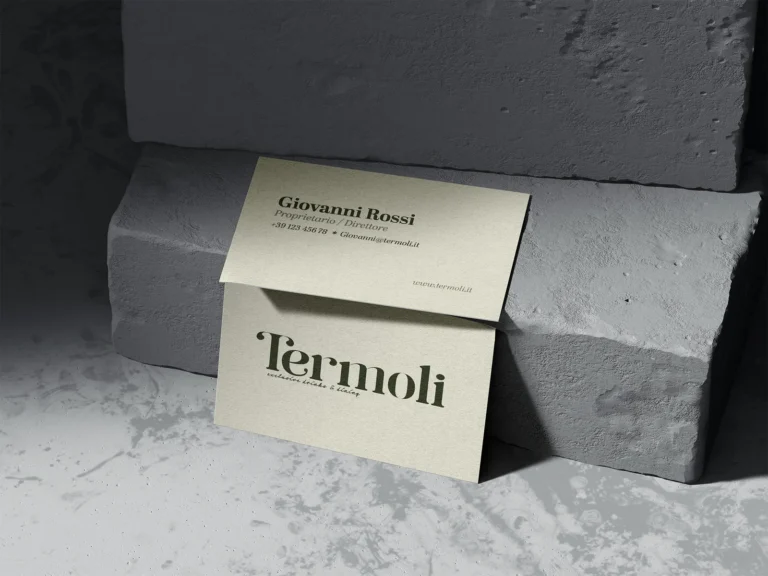 Visitekaartjes van Termoli met het donkergroene woordmerk op gebroken wit papier, tegen grijze steen